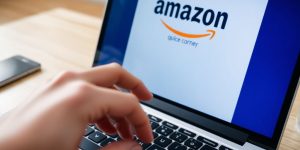 Laptop, Amazon logo, hand clicking, money, shopping cart